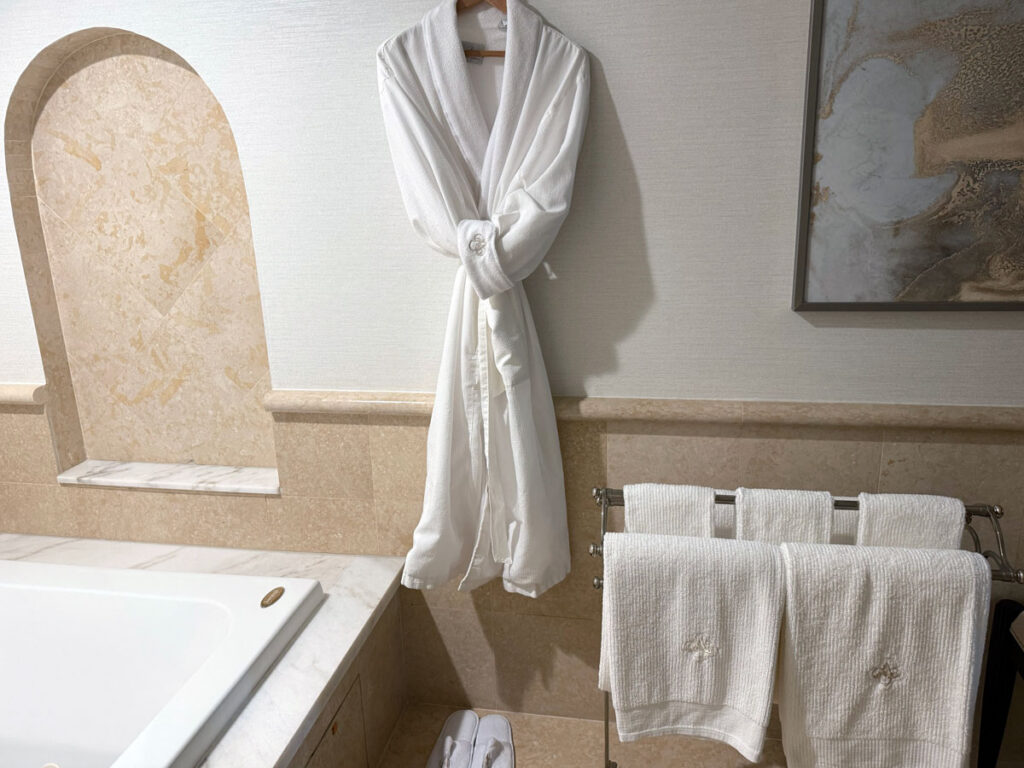 A plush white robe and fresh towels - Acqualina Resort & Residences