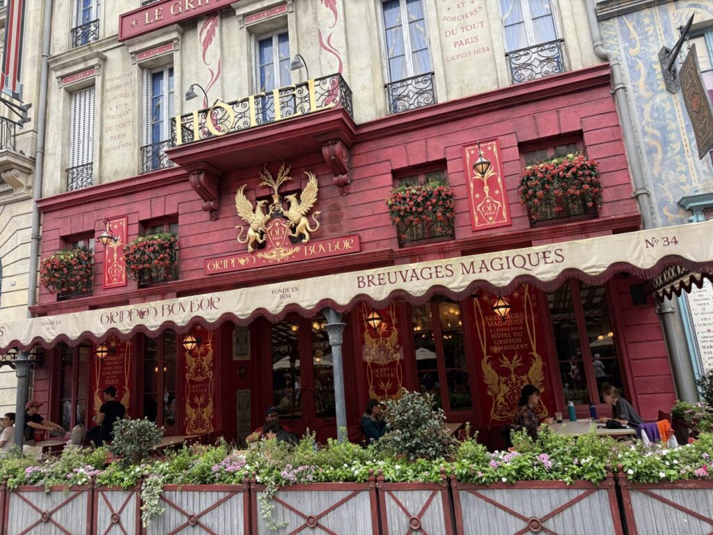 A red Parisian-style building with a Breuvages Magiques awning